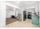 Open kitchen features teal cabinets, stainless steel appliances, and a view into the living room at 2728 Renshaw St, Strasburg, CO 80136