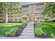 Condominium building with a landscaped entrance, grassy area and mature trees at 350 S Clinton St # 8C, Denver, CO 80247