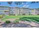 Multi-story condo building featuring green lawn and well-maintained landscaping at 350 S Clinton St # 8C, Denver, CO 80247