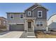 Charming two-story home featuring gray siding, stone accents, and a welcoming front porch at 22014 E 39Th Ave, Aurora, CO 80019