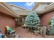 Charming courtyard with brick flooring, a beautiful blue spruce, and cozy seating, perfect for relaxing at 2800 S University Blvd # 1, Denver, CO 80210