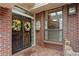 Elegant brick home entrance featuring ornate iron doors adorned with floral wreaths and a welcoming doormat at 2800 S University Blvd # 1, Denver, CO 80210