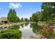 Scenic view of a tranquil pond with lush greenery, trees, and landscaping surrounding the water at 2800 S University Blvd # 1, Denver, CO 80210