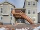 Two story home with a deck, stairs, rock landscaping and grey siding at 12953 Bridge View Ln, Parker, CO 80134