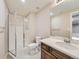 Bathroom featuring a shower with a glass door and a sink vanity with storage and faucet at 12953 Bridge View Ln, Parker, CO 80134