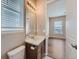 Bathroom with a single vanity, mirror, and an open doorway into the bedroom at 12953 Bridge View Ln, Parker, CO 80134