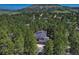 Aerial view of the home surrounded by lush trees and mountain range backdrop at 970 Bend In The Trail Rd, Monument, CO 80132