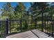A wooden deck offers a private outdoor space surrounded by mature trees and lush greenery at 970 Bend In The Trail Rd, Monument, CO 80132