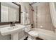Well-appointed bathroom with a pedestal sink, bathtub with tiled surround, and modern fixtures at 970 Bend In The Trail Rd, Monument, CO 80132
