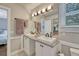 Dual sink bathroom vanity with granite countertop, framed mirror and overhead lighting at 970 Bend In The Trail Rd, Monument, CO 80132