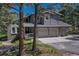 Two-story home with a three-car garage and stone accents surrounded by mature trees at 970 Bend In The Trail Rd, Monument, CO 80132