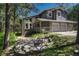 Two-story home with a three-car garage and stone accents surrounded by mature trees at 970 Bend In The Trail Rd, Monument, CO 80132