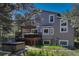 Back exterior with a large deck featuring a hot tub and outdoor seating area at 970 Bend In The Trail Rd, Monument, CO 80132