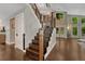 Welcoming foyer with hardwood floors, a staircase featuring rod iron details, and abundant natural light at 970 Bend In The Trail Rd, Monument, CO 80132