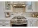 Modern kitchen featuring a stainless steel range and marble backsplash at 970 Bend In The Trail Rd, Monument, CO 80132