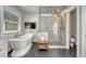 Bright main bathroom featuring a soaking tub and a glass-enclosed shower with tiled surround at 970 Bend In The Trail Rd, Monument, CO 80132