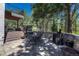 A concrete outdoor patio featuring a table and chairs, grill and a partial stone fence at 970 Bend In The Trail Rd, Monument, CO 80132