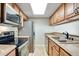 Well-lit kitchen features stainless steel appliances and light wood cabinets at 7845 Barbara Ann Dr # J, Arvada, CO 80004