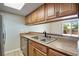 Functional kitchen area with a double sink, breakfast bar and wood cabinets for ample storage at 7845 Barbara Ann Dr # J, Arvada, CO 80004
