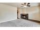 Spacious living room with a brick fireplace, neutral carpet, and an open stairway at 7845 Barbara Ann Dr # J, Arvada, CO 80004
