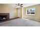 Inviting living room featuring a cozy fireplace, neutral carpet, and a bright window at 7845 Barbara Ann Dr # J, Arvada, CO 80004