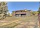 Expansive backyard featuring a multi-level deck and patio, enclosed by a wooden fence, and mature trees at 20120 Doewood Dr, Monument, CO 80132