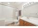 Bright bathroom with tub, shower, white tile, and wooden vanity at 20120 Doewood Dr, Monument, CO 80132