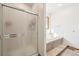 Bright bathroom features a glass shower and tiled tub with steps for easy access at 20120 Doewood Dr, Monument, CO 80132