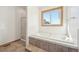 Bright bathroom with a soaking tub, tile surround, separate shower, and natural light from the window at 20120 Doewood Dr, Monument, CO 80132