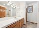 Bathroom vanity featuring a large mirror, tiled countertop, and wood cabinets at 20120 Doewood Dr, Monument, CO 80132