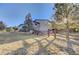 A home with a spacious yard surrounded by a wooden fence with mature trees at 20120 Doewood Dr, Monument, CO 80132
