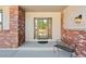 Cozy covered front porch with brick accents, offering a welcoming entrance to the home at 20120 Doewood Dr, Monument, CO 80132