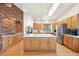 Open kitchen with a large center island, stainless steel appliances, and a brick accent wall at 20120 Doewood Dr, Monument, CO 80132