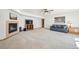 Large living room with a fireplace, blue sofa, ceiling fan, and carpet at 20120 Doewood Dr, Monument, CO 80132