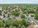Aerial view of a neighborhood with mature trees and city views in the distance at 2013 S Holland St, Lakewood, CO 80227