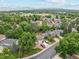 Aerial view of a neighborhood with mature trees and mountain views in the distance at 2013 S Holland St, Lakewood, CO 80227