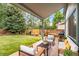 Relaxing covered back patio with comfortable seating and views of the green backyard at 2013 S Holland St, Lakewood, CO 80227