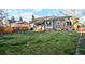 Expansive backyard with a lush lawn, mature trees, patio, and exterior view of the home at 2013 S Holland St, Lakewood, CO 80227