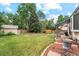 Large backyard featuring mature trees, lush grass, and a storage shed at 2013 S Holland St, Lakewood, CO 80227