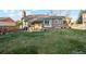 Spacious backyard featuring a patio, lush green lawn, and exterior view of the home's rear elevation at 2013 S Holland St, Lakewood, CO 80227