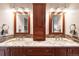 Elegant bathroom with dual sinks, granite countertops, wooden cabinets and decorative mirror at 2013 S Holland St, Lakewood, CO 80227