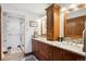 Bright bathroom featuring dual sinks with granite countertops, wood cabinets, and a glass door shower at 2013 S Holland St, Lakewood, CO 80227