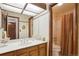 Well-maintained bathroom featuring a large vanity, decorative wallpaper, and a shower/tub combination at 2013 S Holland St, Lakewood, CO 80227