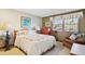 Charming bedroom featuring a queen bed, patterned quilt, and a bright window at 2013 S Holland St, Lakewood, CO 80227