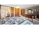 Spacious bedroom featuring a king-sized bed, wood furnishings, and a sliding barn door to the en suite bathroom at 2013 S Holland St, Lakewood, CO 80227