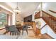 Open dining area with hardwood floors, large window, and a view of the living room and fireplace at 2013 S Holland St, Lakewood, CO 80227