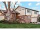 Charming two-story home with brick accents, landscaped yard, and inviting front entrance, creating a warm and welcoming curb appeal at 2013 S Holland St, Lakewood, CO 80227