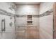 Walk-in shower with chrome fixtures, tiled walls, and a built-in niche for storage at 2013 S Holland St, Lakewood, CO 80227