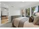 Bright bedroom with two large windows, a gray dresser and a glimpse into the hallway and stairs at 380 S Humboldt St, Denver, CO 80209