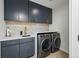 Functional laundry room with contemporary cabinetry, countertops, and high-efficiency washer and dryer at 380 S Humboldt St, Denver, CO 80209